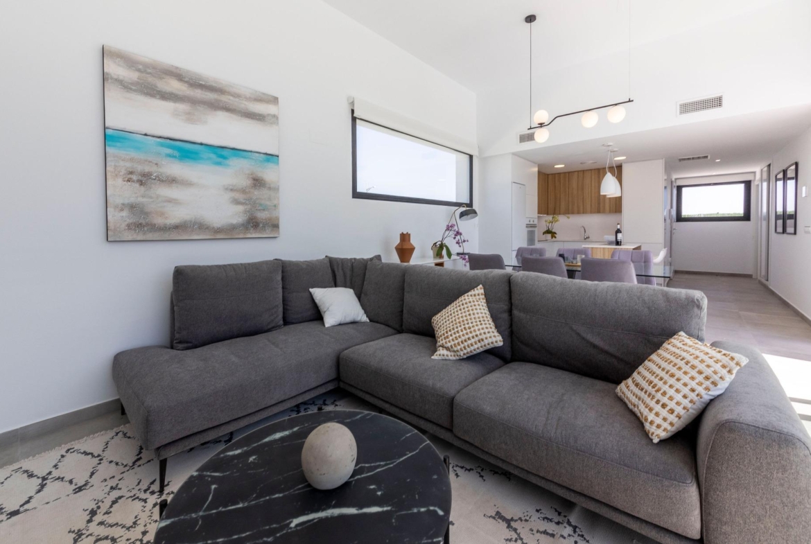 Bright, modern living room with elegant sectional sofa and open-plan kitchen in luxury 3-bedroom villa, Calasparra, Murcia.