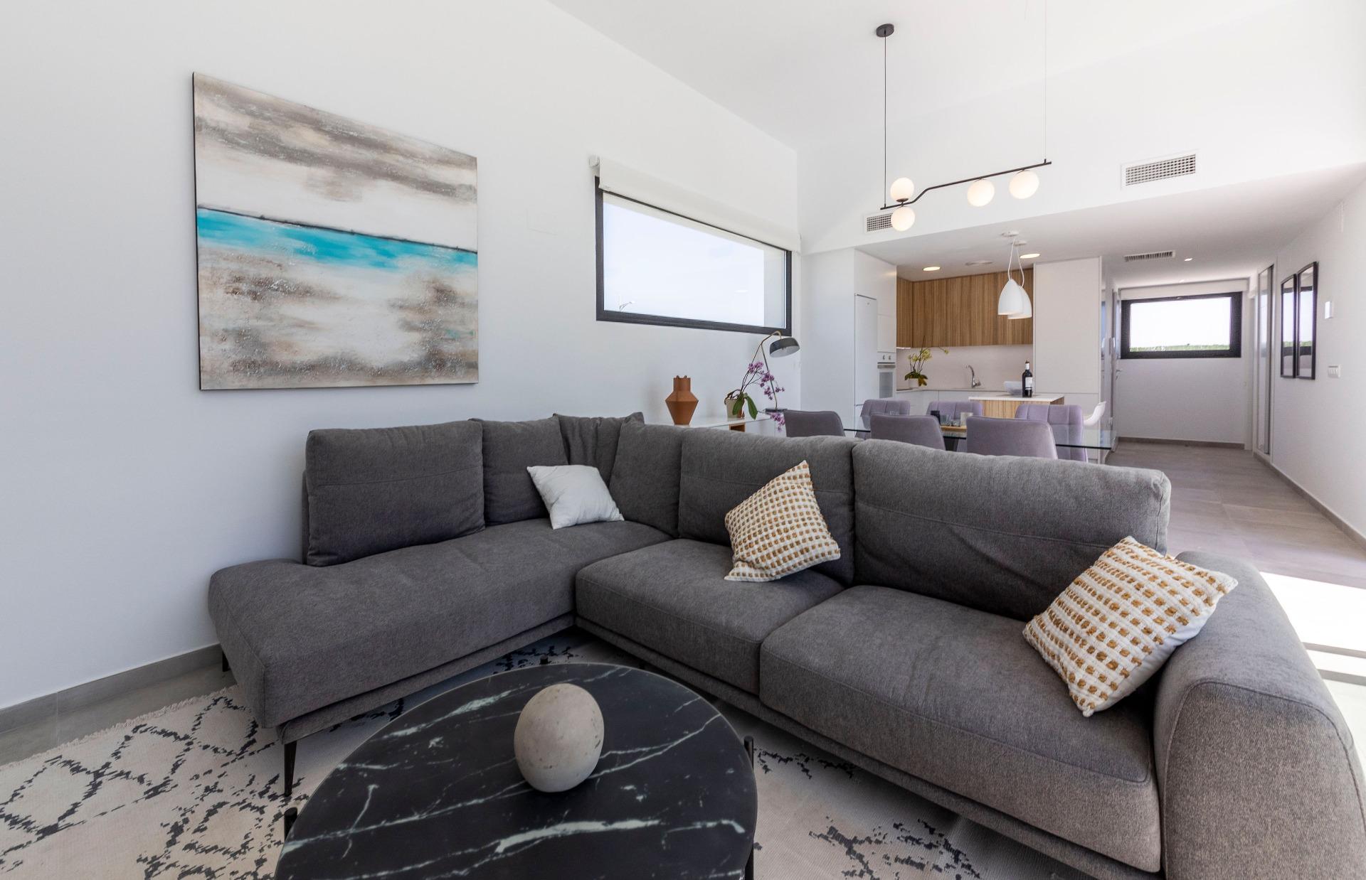Bright, modern living room with elegant sectional sofa and open-plan kitchen in luxury 3-bedroom villa, Calasparra, Murcia.