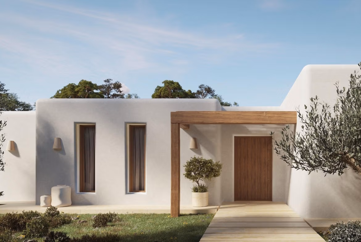 Elegant Ibizan-style single-storey villa entrance in La Fustera, Benissa, featuring smooth white walls and natural wooden accents.