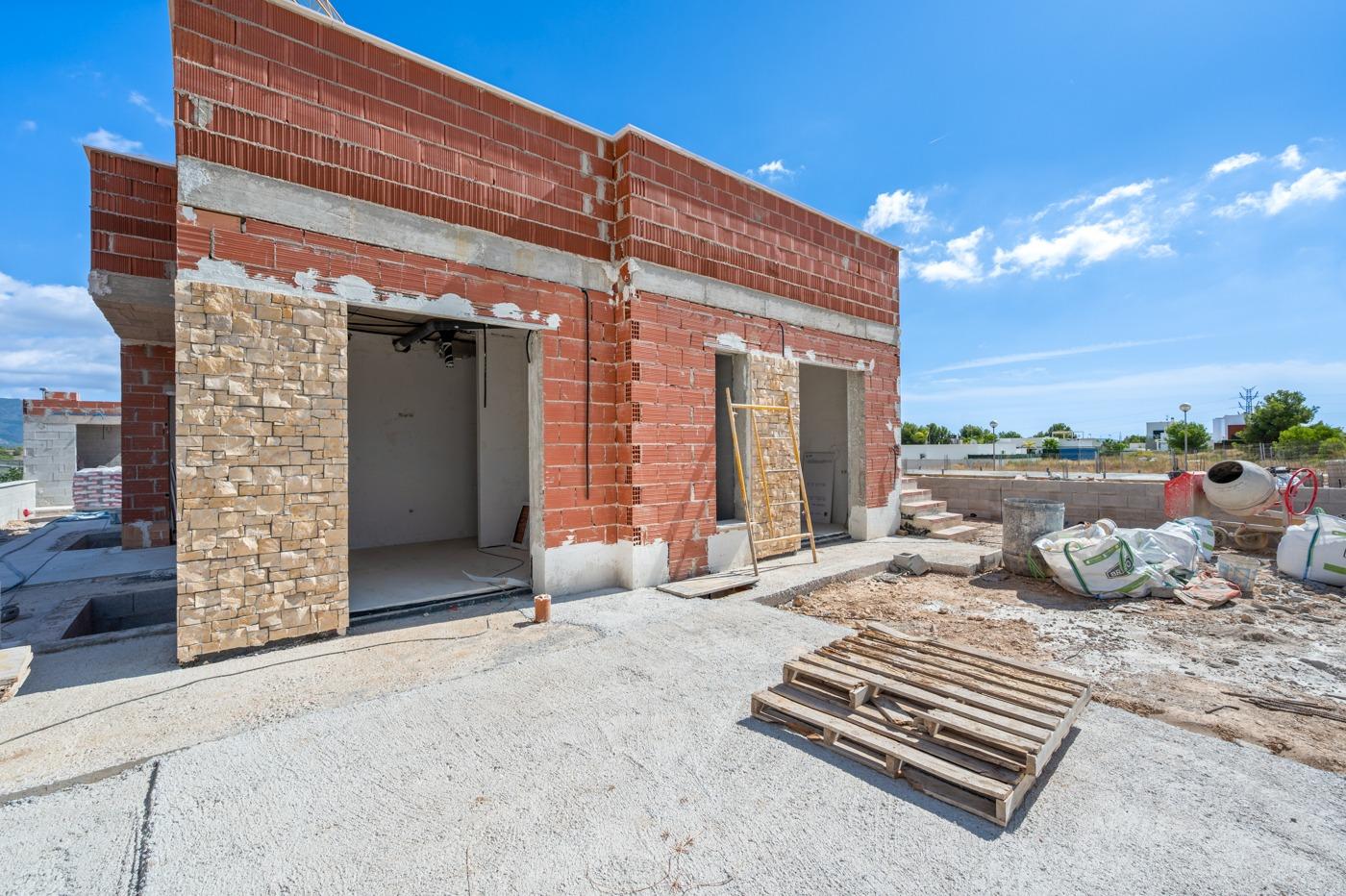 Unfinished luxury 5 bedroom villa under construction in Polop de la Marina with spacious exterior and bright blue sky backdrop