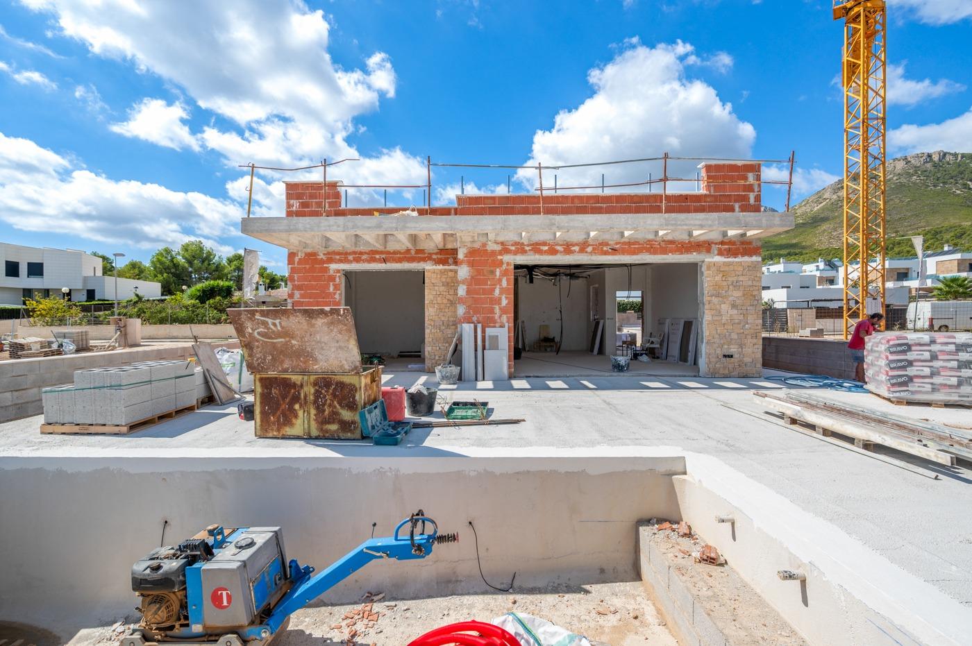 Under-construction spacious luxury 5-bedroom villa in Polop de la Marina with mountain views and modern architectural design.