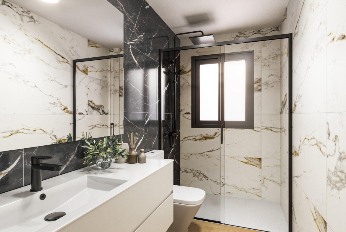Modern luxury bathroom with sleek black and white marble, spacious shower, and elegant fixtures in Torrevieja ground floor apartment.