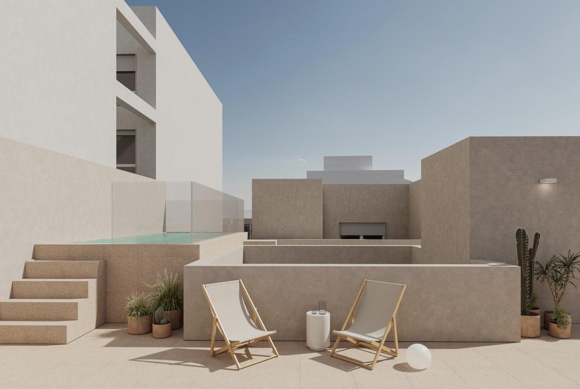 Modern sun-drenched terrace with lounge chairs and raised pool in spacious new build 2-bedroom apartment in central Torrevieja.