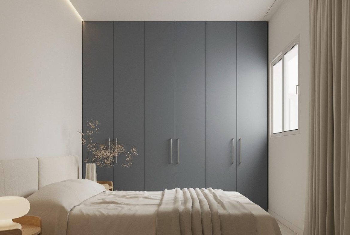 Bright modern bedroom with soft neutral tones and sleek storage in spacious 2-bedroom apartment in central Torrevieja.