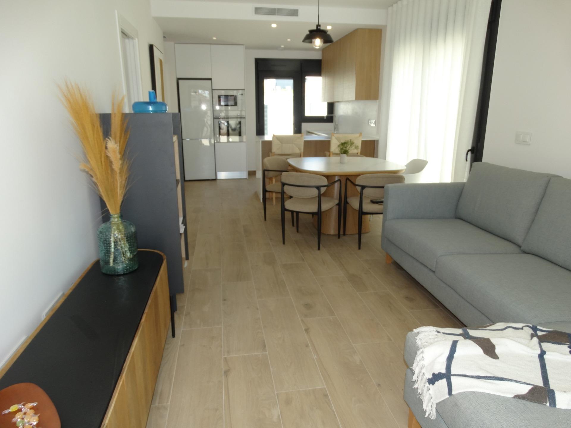 Modern-New-Build-Bungalows-for-Sale-in-Pilar-de-la-Horadada-12 Bright, modern open-plan living and dining area with sleek kitchen in luxury new build bungalow for sale in Pilar de la Horadada.