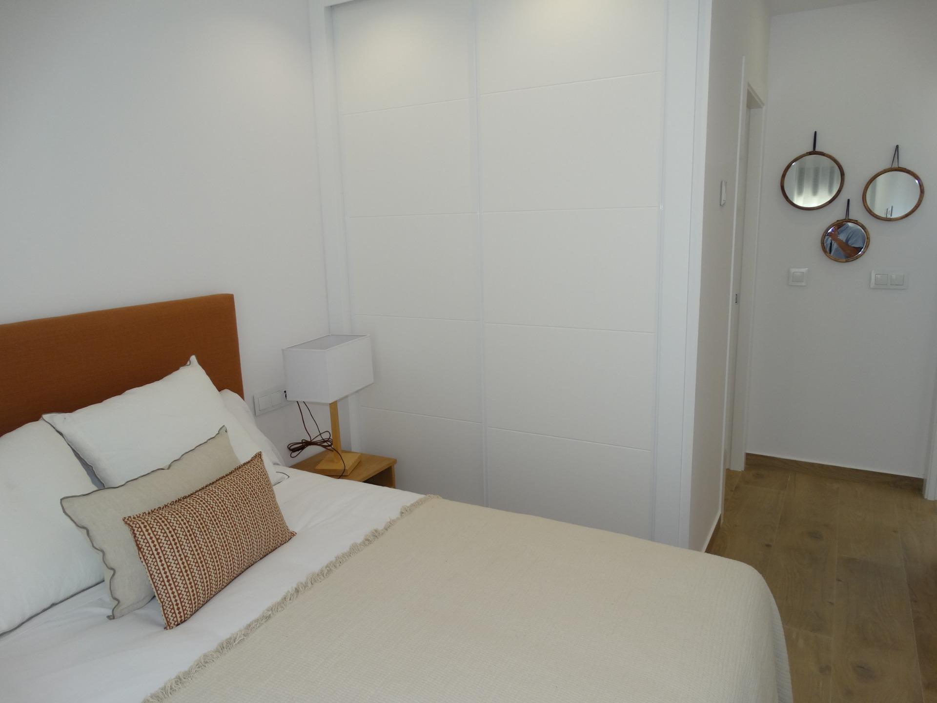 Modern-New-Build-Bungalows-for-Sale-in-Pilar-de-la-Horadada-13 Bright modern bedroom with elegant bedding and minimalist decor in a new build bungalow in Pilar de la Horadada