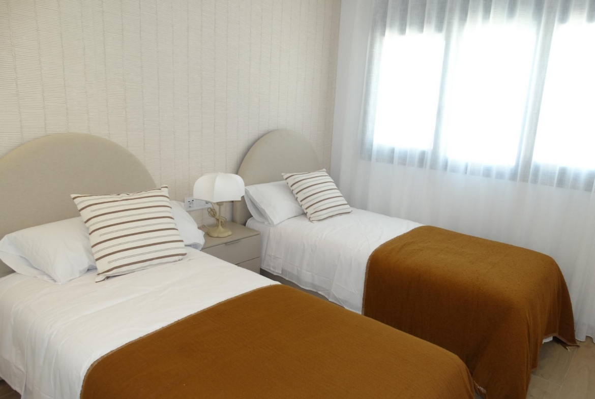 Modern-New-Build-Bungalows-for-Sale-in-Pilar-de-la-Horadada-15 Bright, modern twin bedroom with cozy bedding and soft natural light in luxury new build bungalows in Pilar de la Horadada
