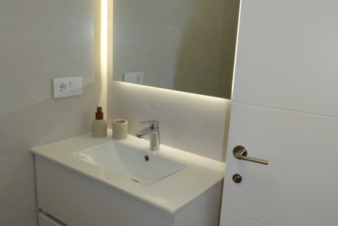 Modern-New-Build-Bungalows-for-Sale-in-Pilar-de-la-Horadada-17 Sleek modern bathroom with illuminated mirror and minimalist vanity in new build bungalows, Pilar de la Horadada