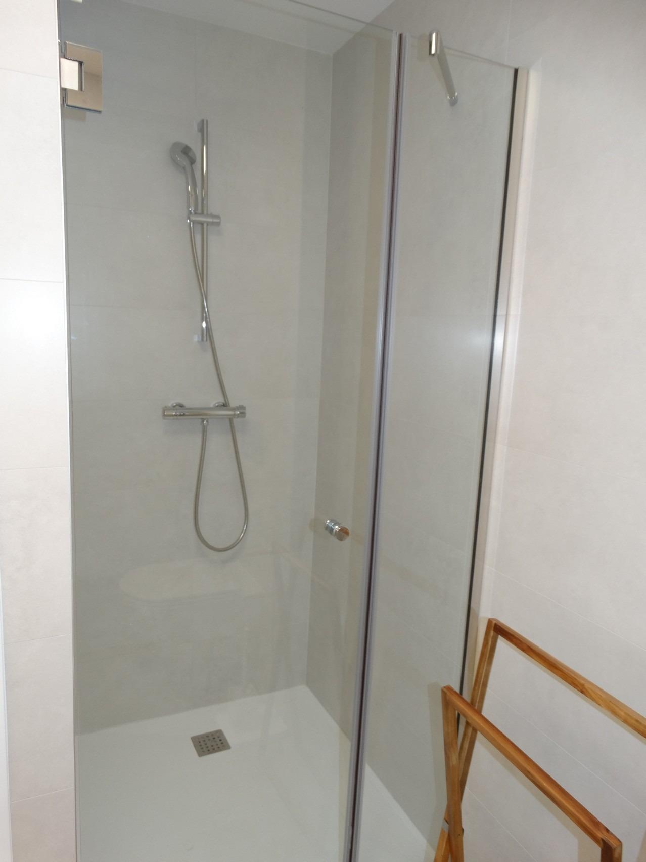 Modern new build bungalow in Pilar de la Horadada featuring a sleek, minimalist shower with glass enclosure and elegant fixtures.