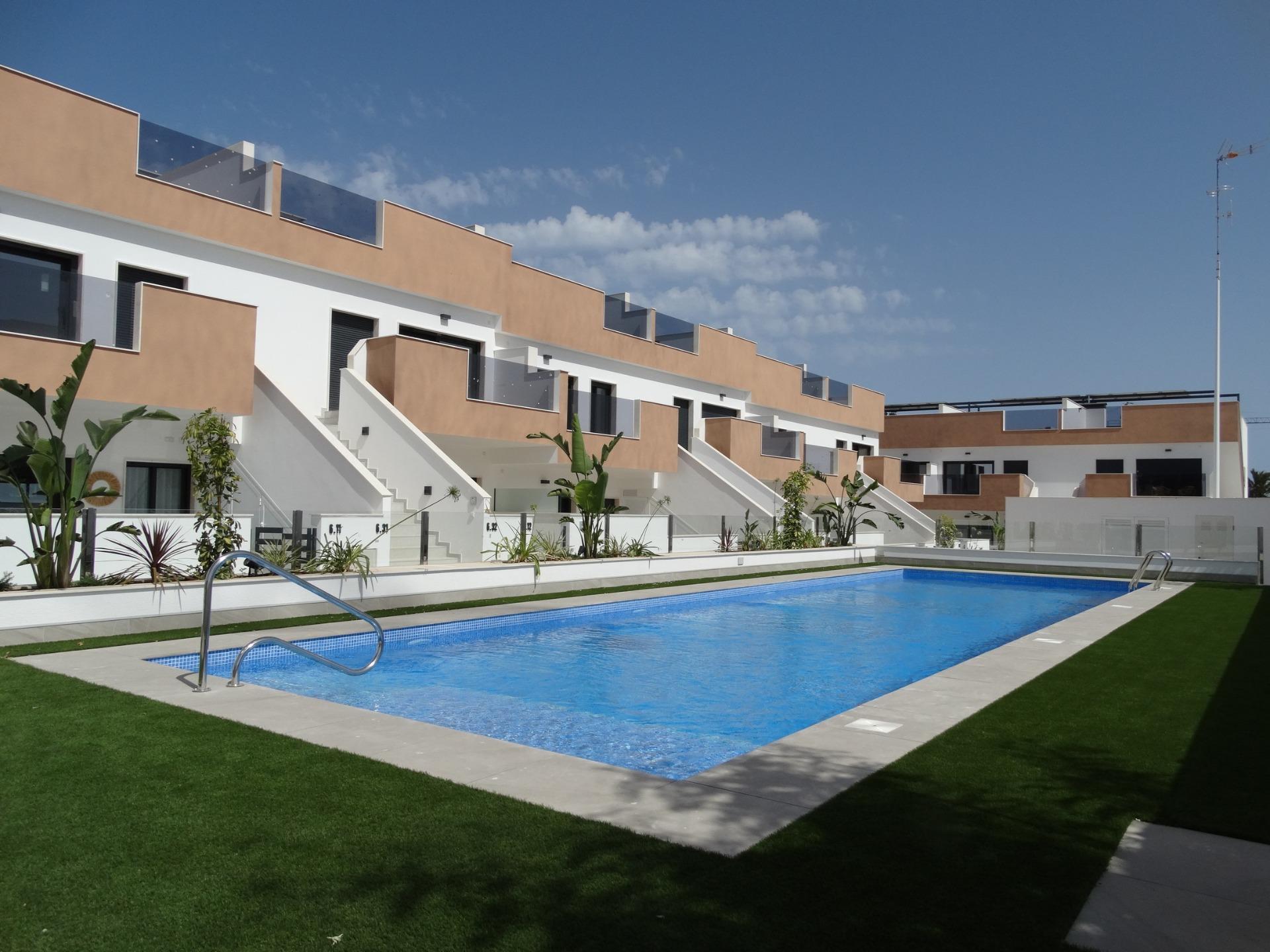 Modern-New-Build-Bungalows-for-Sale-in-Pilar-de-la-Horadada-2 Modern new build bungalows in Pilar de la Horadada with a sleek communal pool and landscaped sun-drenched exterior terraces