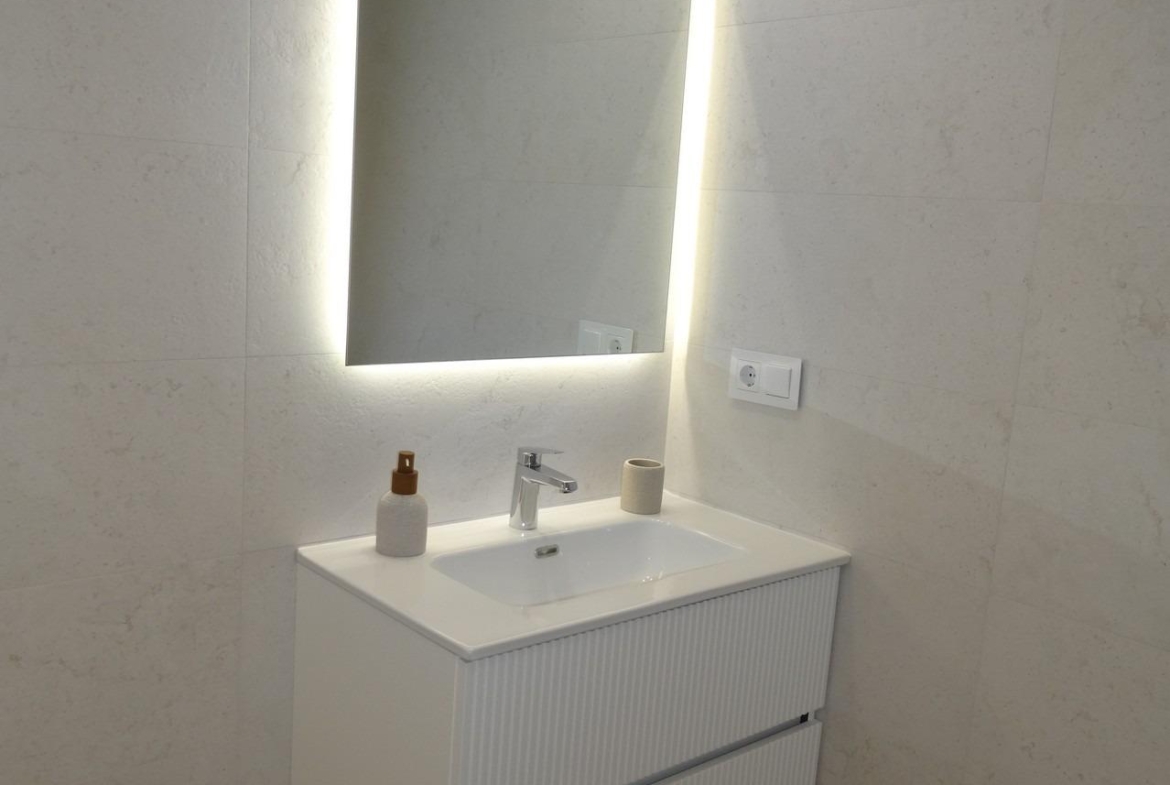 Modern-New-Build-Bungalows-for-Sale-in-Pilar-de-la-Horadada-21 Bright modern bathroom vanity with illuminated mirror in luxury new build bungalow in Pilar de la Horadada