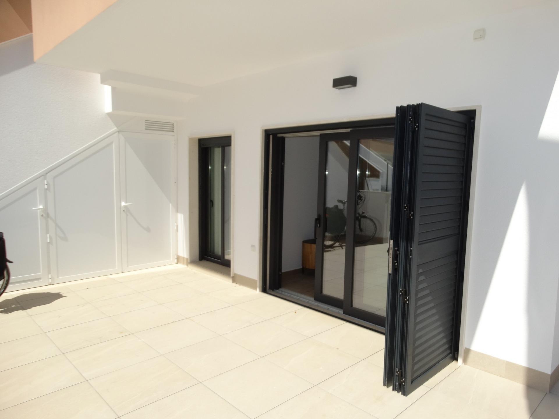 Modern-New-Build-Bungalows-for-Sale-in-Pilar-de-la-Horadada-25 Bright spacious sun-drenched terrace with modern folding doors in luxury new build bungalow in Pilar de la Horadada