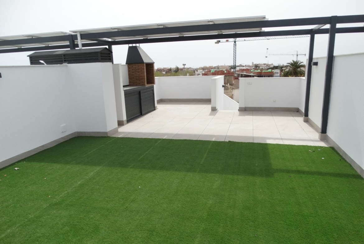 Modern-New-Build-Bungalows-for-Sale-in-Pilar-de-la-Horadada-3 Spacious sun-drenched terrace with built-in barbecue and artificial lawn at modern new build bungalows in Pilar de la Horadada