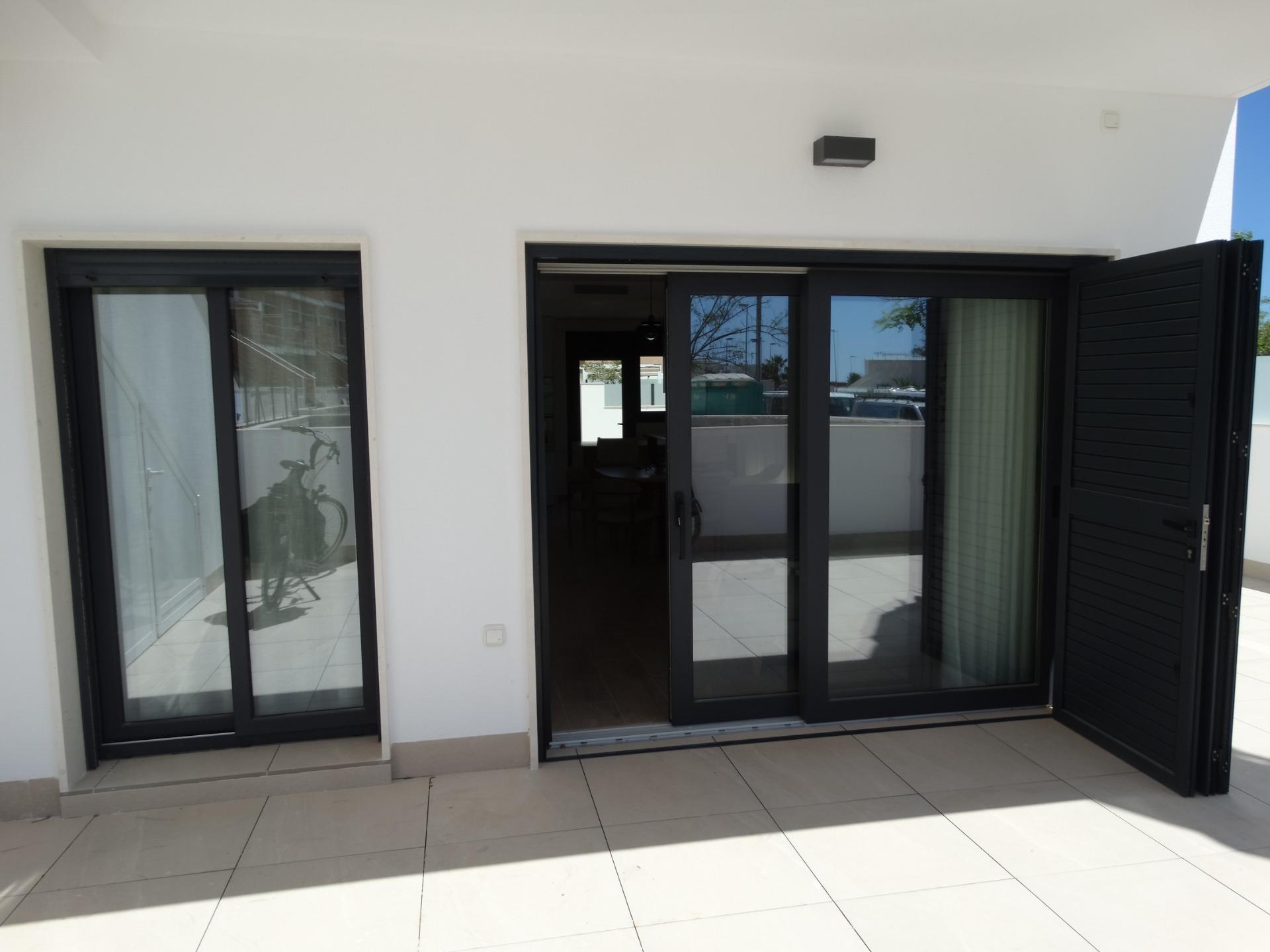 Modern-New-Build-Bungalows-for-Sale-in-Pilar-de-la-Horadada-5 Bright modern terrace with sleek glass doors in luxury new build bungalow in Pilar de la Horadada