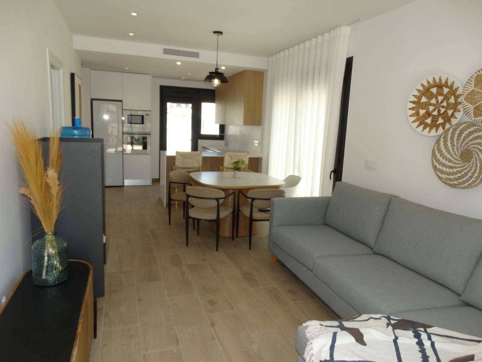 Modern-New-Build-Bungalows-for-Sale-in-Pilar-de-la-Horadada-6 Bright open-plan living and kitchen area with modern furnishings in a stylish new build bungalow in Pilar de la Horadada.