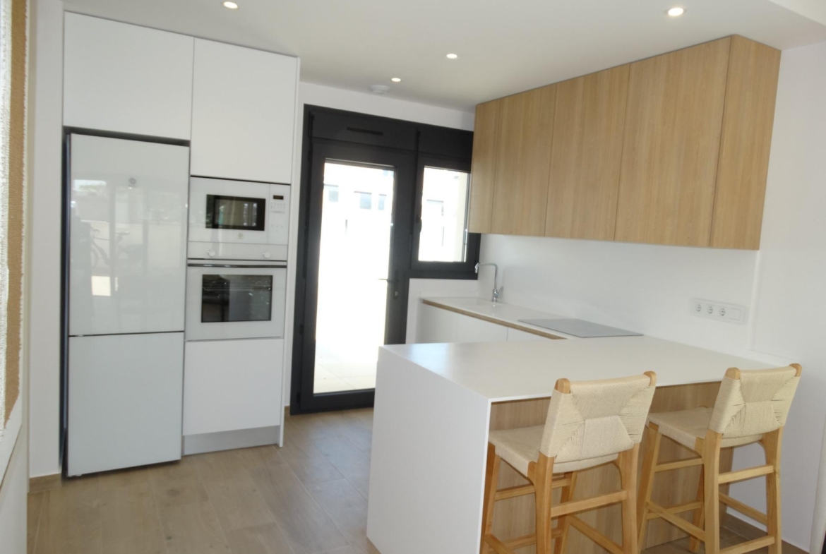 Modern-New-Build-Bungalows-for-Sale-in-Pilar-de-la-Horadada-8 Bright modern kitchen with sleek cabinetry and breakfast bar in new build bungalows for sale in Pilar de la Horadada