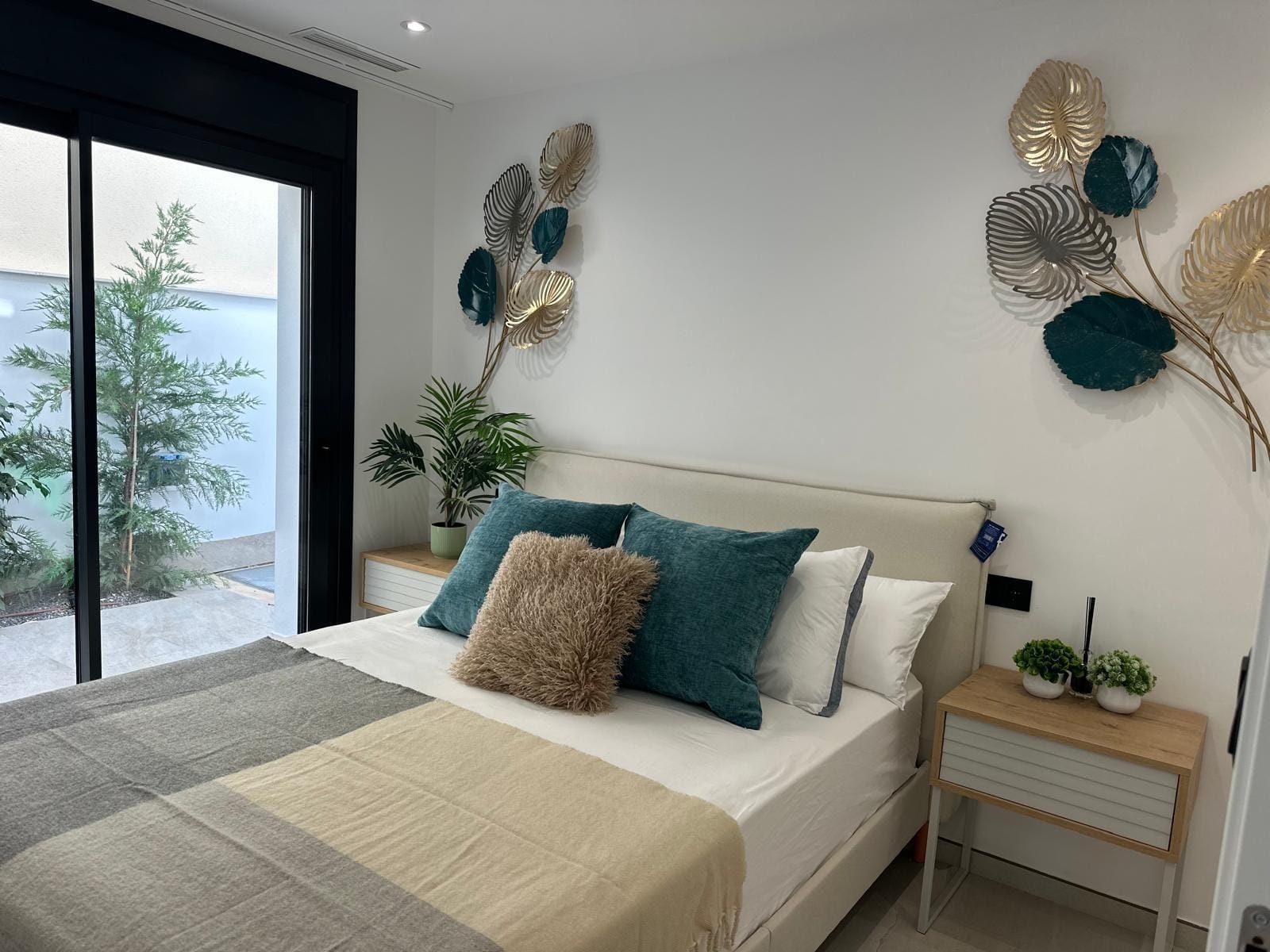 Modern-New-Build-Villas-for-Sale-in-San-Pedro-del-Pinatar-–-Close-to-Beach-and-Town-Centre-12 Bright, elegant bedroom with plush cushions and decorative wall art in key-ready new build villa, San Pedro del Pinatar, Costa Cálida.