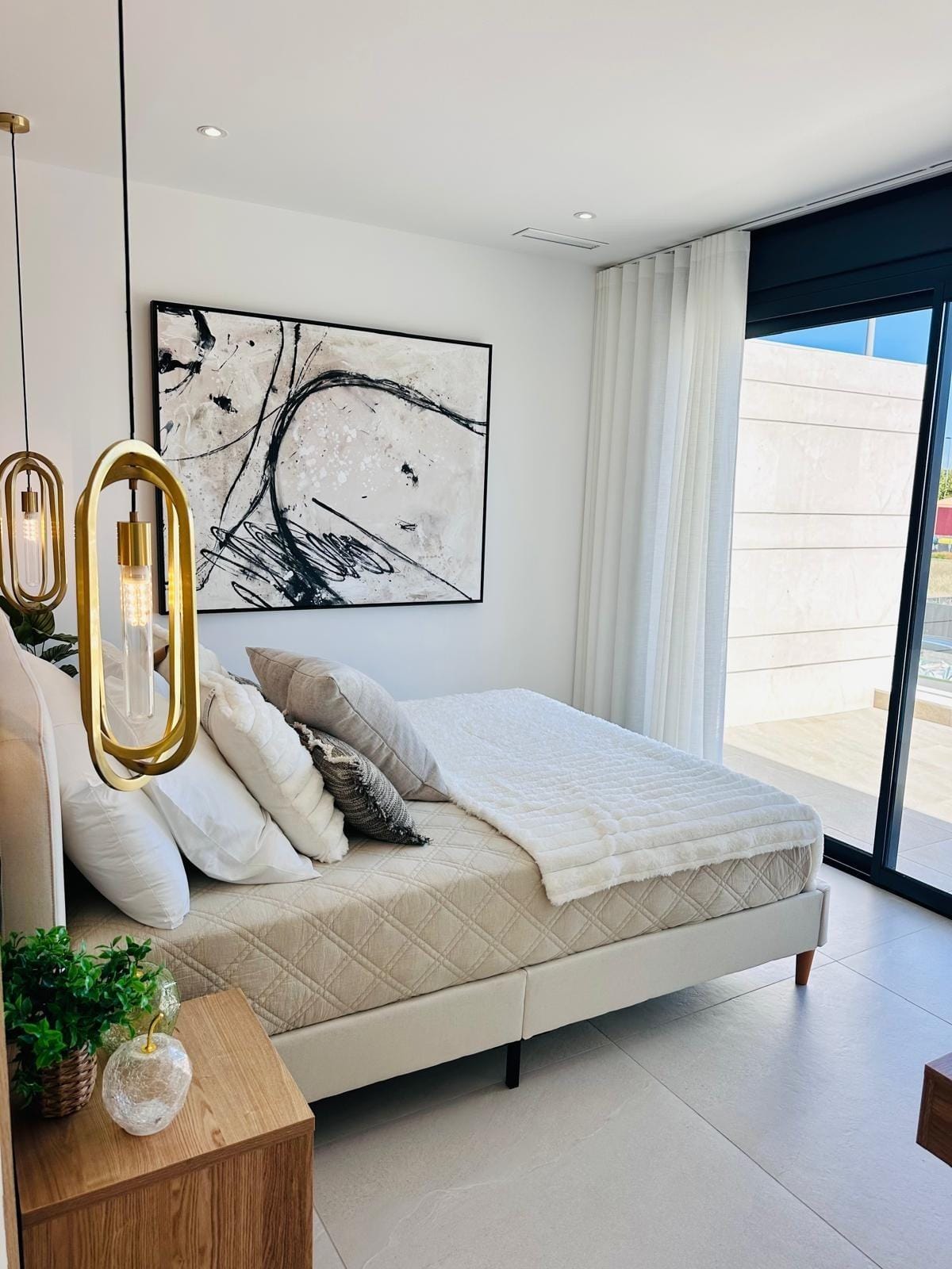 Modern-New-Build-Villas-for-Sale-in-San-Pedro-del-Pinatar-–-Close-to-Beach-and-Town-Centre-14 Bright, elegant bedroom with modern gold pendant lights and balcony in key-ready villa in San Pedro del Pinatar, Costa Cálida.