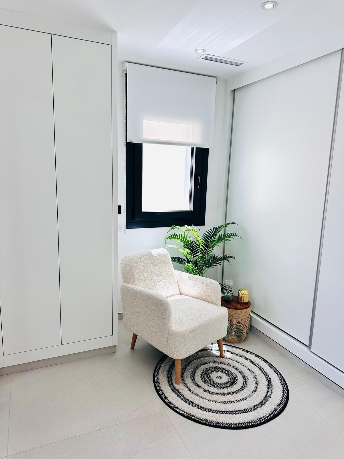 Modern-New-Build-Villas-for-Sale-in-San-Pedro-del-Pinatar-–-Close-to-Beach-and-Town-Centre-16 Bright minimalist reading nook with plush armchair and lush plant in key-ready new build villa in San Pedro del Pinatar, Costa Cálida