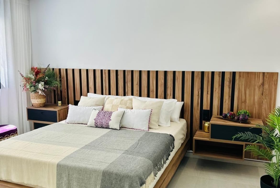 Bright, modern bedroom with elegant wood panel headboard and soft textiles in luxury new build villa in San Pedro del Pinatar