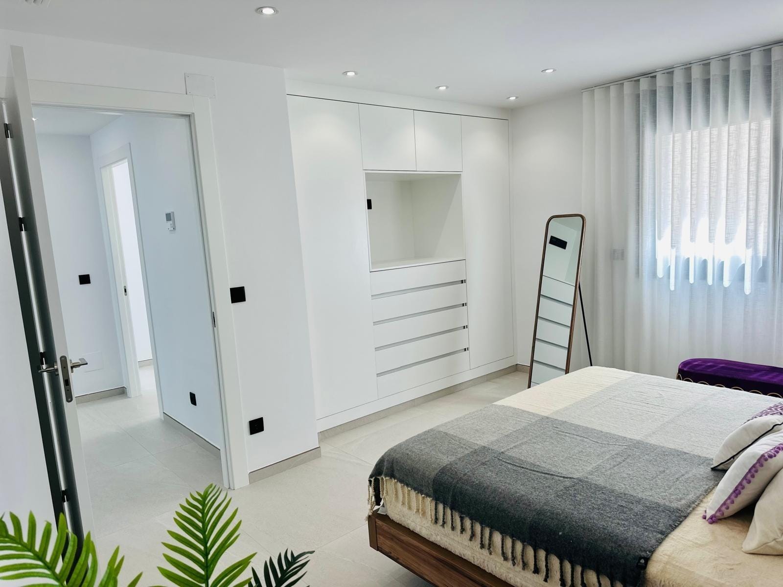 Modern-New-Build-Villas-for-Sale-in-San-Pedro-del-Pinatar-–-Close-to-Beach-and-Town-Centre-21 Bright, modern bedroom with built-in white wardrobes and a wooden bed in a key-ready new build villa in San Pedro del Pinatar.