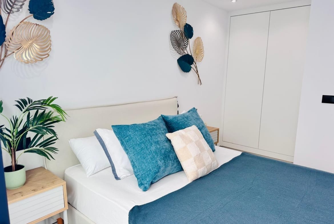 Bright and elegant bedroom with plush blue cushions and modern decor in key-ready new build villa in San Pedro del Pinatar Costa Cálida