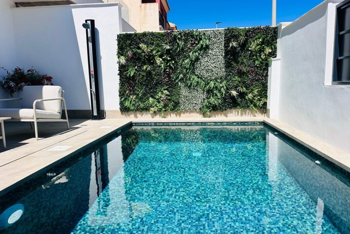 Private sun-drenched pool with vibrant mosaic tiles and lush vertical garden in luxury new build villa in San Pedro del Pinatar, Costa Cálida.