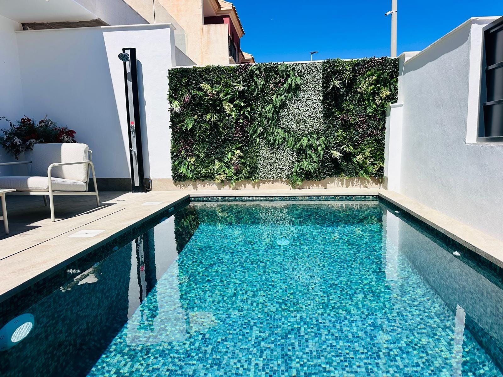 Modern-New-Build-Villas-for-Sale-in-San-Pedro-del-Pinatar-–-Close-to-Beach-and-Town-Centre-3 Private sun-drenched pool with vibrant mosaic tiles and lush vertical garden in luxury new build villa in San Pedro del Pinatar, Costa Cálida.