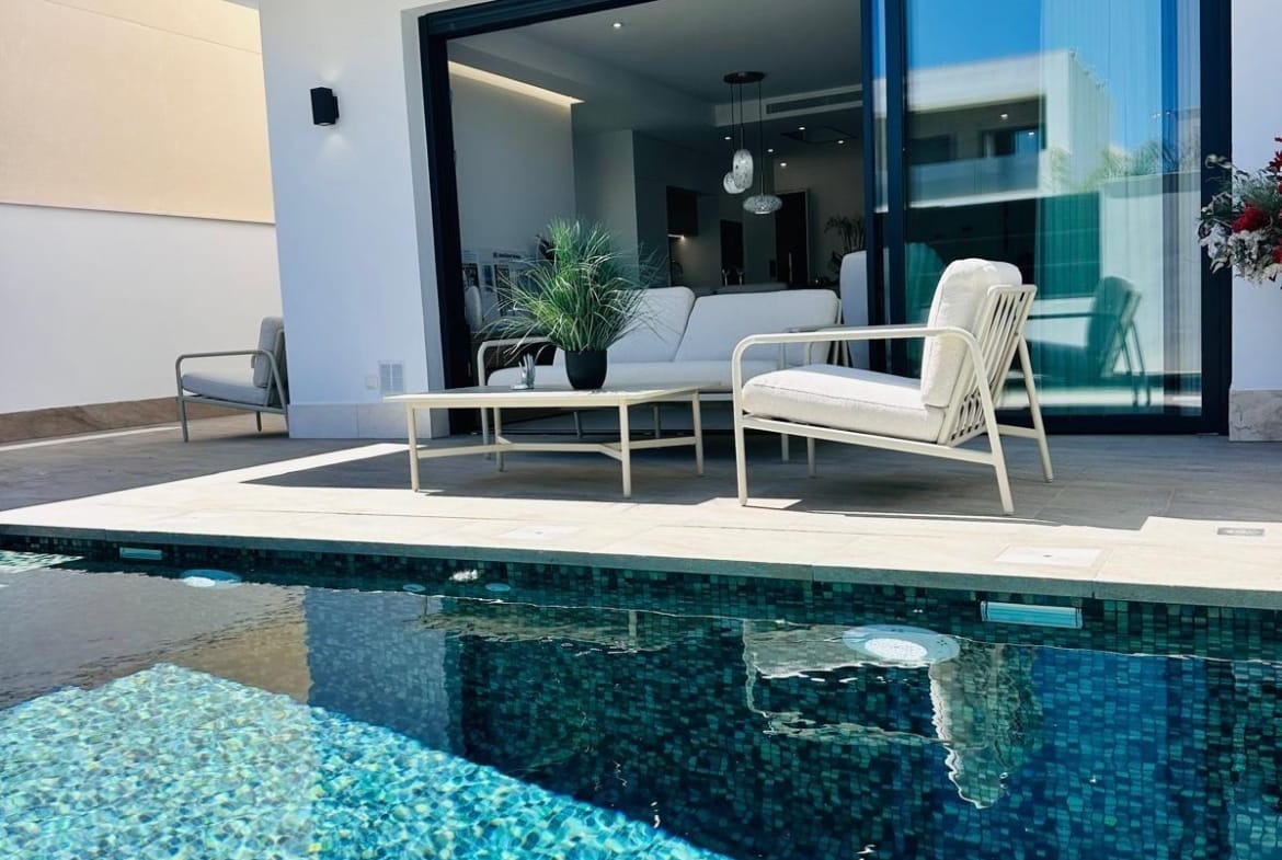 Sunlit private pool and elegant terrace seating of a modern new build villa in San Pedro del Pinatar, Costa Cálida.
