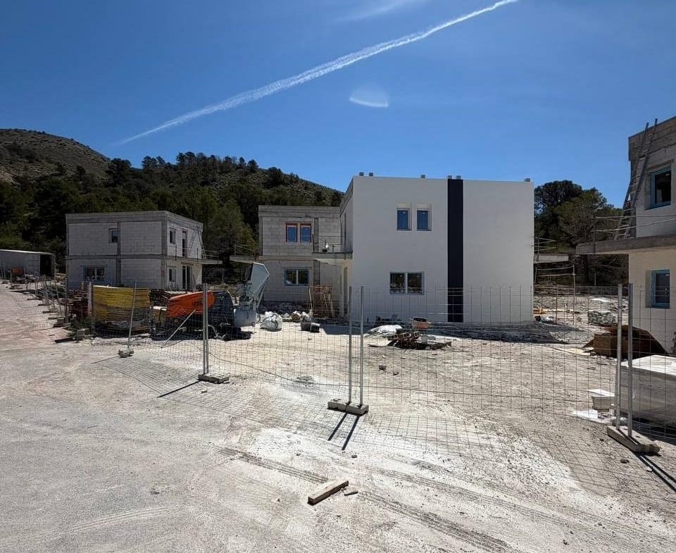 Modern energy-efficient 3-bedroom villa under construction in Finestrat, Benidorm, set against a serene mountainous backdrop.