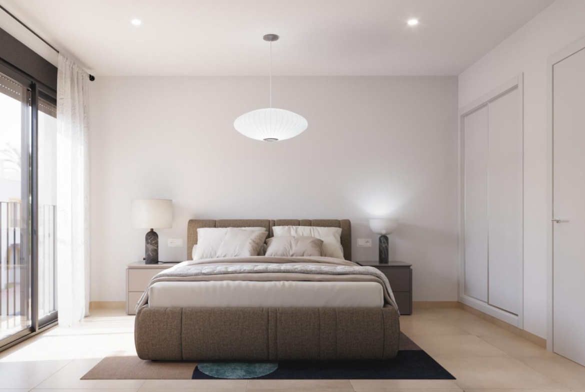 Bright and modern 2 bedroom townhouse bedroom with elegant bed, bedside lamps, and sunlit balcony in Santa Rosalía, Torre Pacheco.