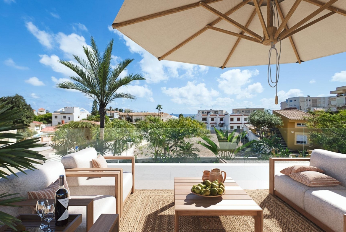 Sunlit terrace with modern seating, lush greenery, and ocean views at a luxury villa in Cabo de Palos, Costa Cálida.