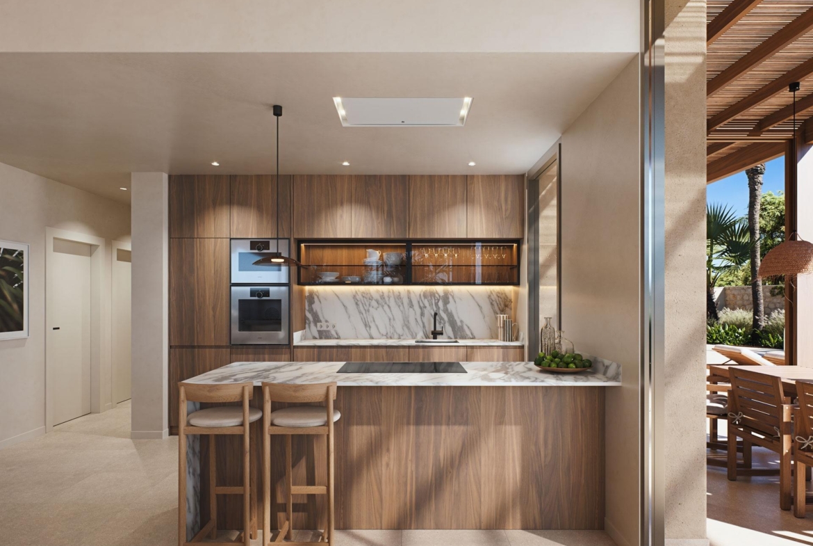 Sunlit modern kitchen with marble island and wooden cabinetry in a luxury villa near the beach in Cabo de Palos, Costa Cálida.