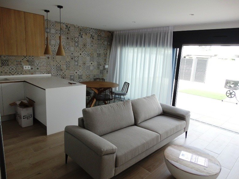 Bright open-plan living and kitchen area with modern furnishings in a 3-bedroom semi-detached villa in Pilar de la Horadada