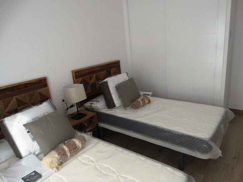 Bright modern twin bedroom with stylish wooden headboards in a new 3 bedroom semi-detached villa in Pilar de la Horadada
