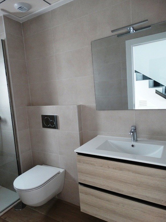 Bright modern bathroom with sleek fixtures and wood-effect vanity in 3-bedroom semi-detached villa in Pilar de la Horadada