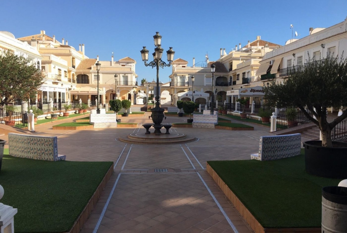 Bright, spacious plaza with elegant street lamps surrounded by modern semi-detached villas in Pilar de la Horadada