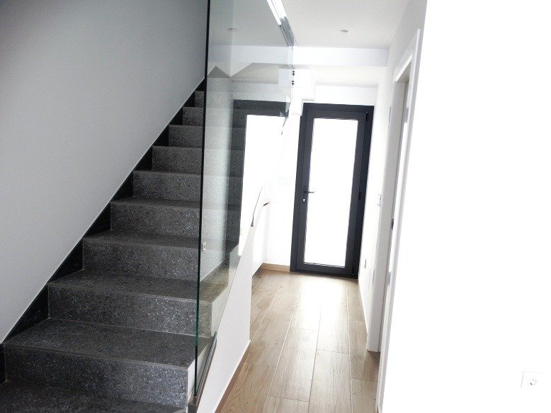 Bright modern hallway with sleek stone staircase and wooden flooring in a 3-bedroom semi-detached villa in Pilar de la Horadada