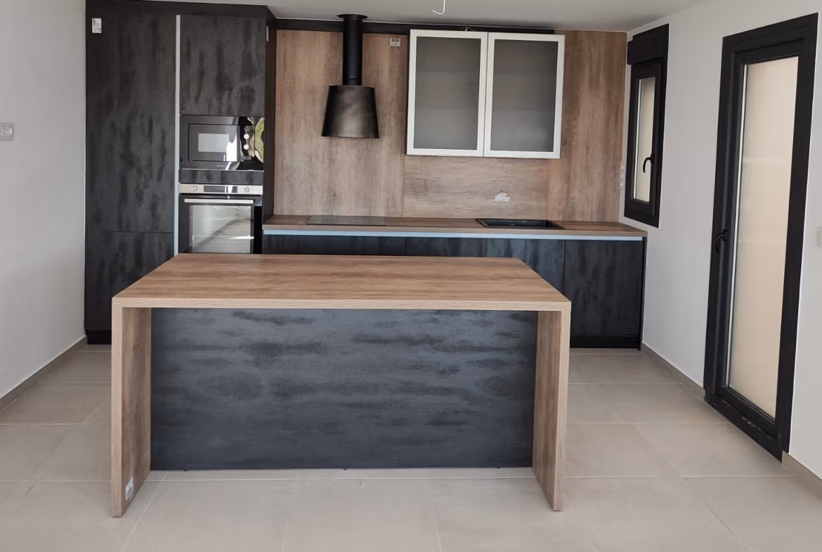 Modern open-plan kitchen with sleek cabinetry and wood accents in a new 3-bedroom apartment in Torre-Pacheco, Murcia