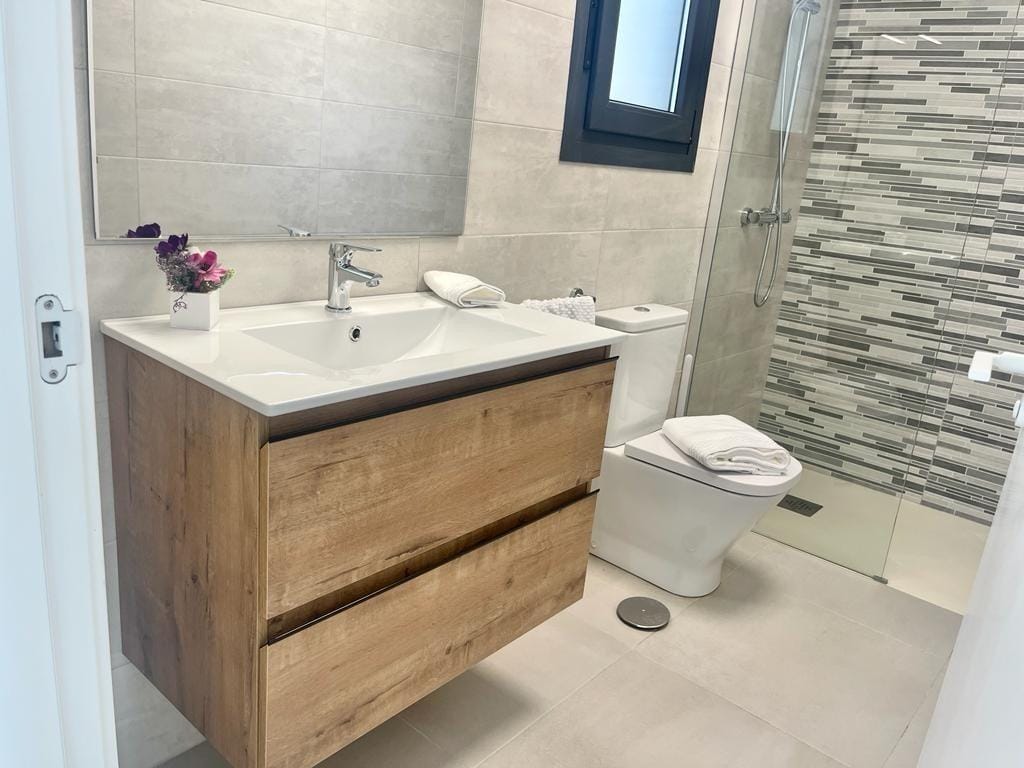 Modern bathroom with sleek wood vanity and glass shower in new build 3 bedroom apartment in Torre-Pacheco, Murcia