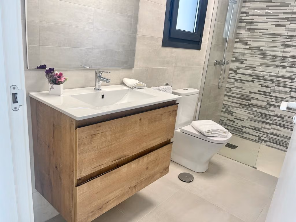 Modern bathroom with sleek wood vanity and glass shower in new build 3 bedroom apartment in Torre-Pacheco, Murcia