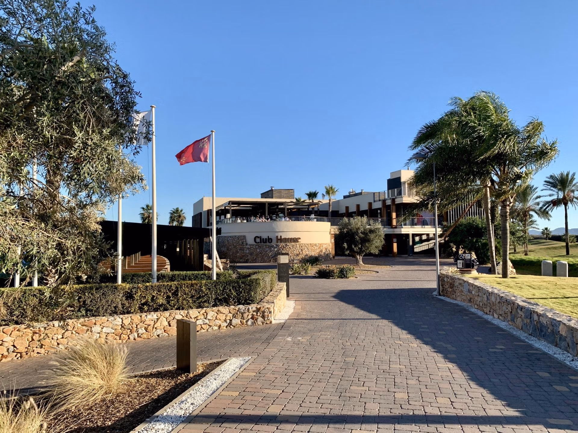 Stunning entrance to Roda Golf clubhouse with landscaped lawns and palm trees, near spacious 3-bedroom ground floor bungalow in San Javier.
