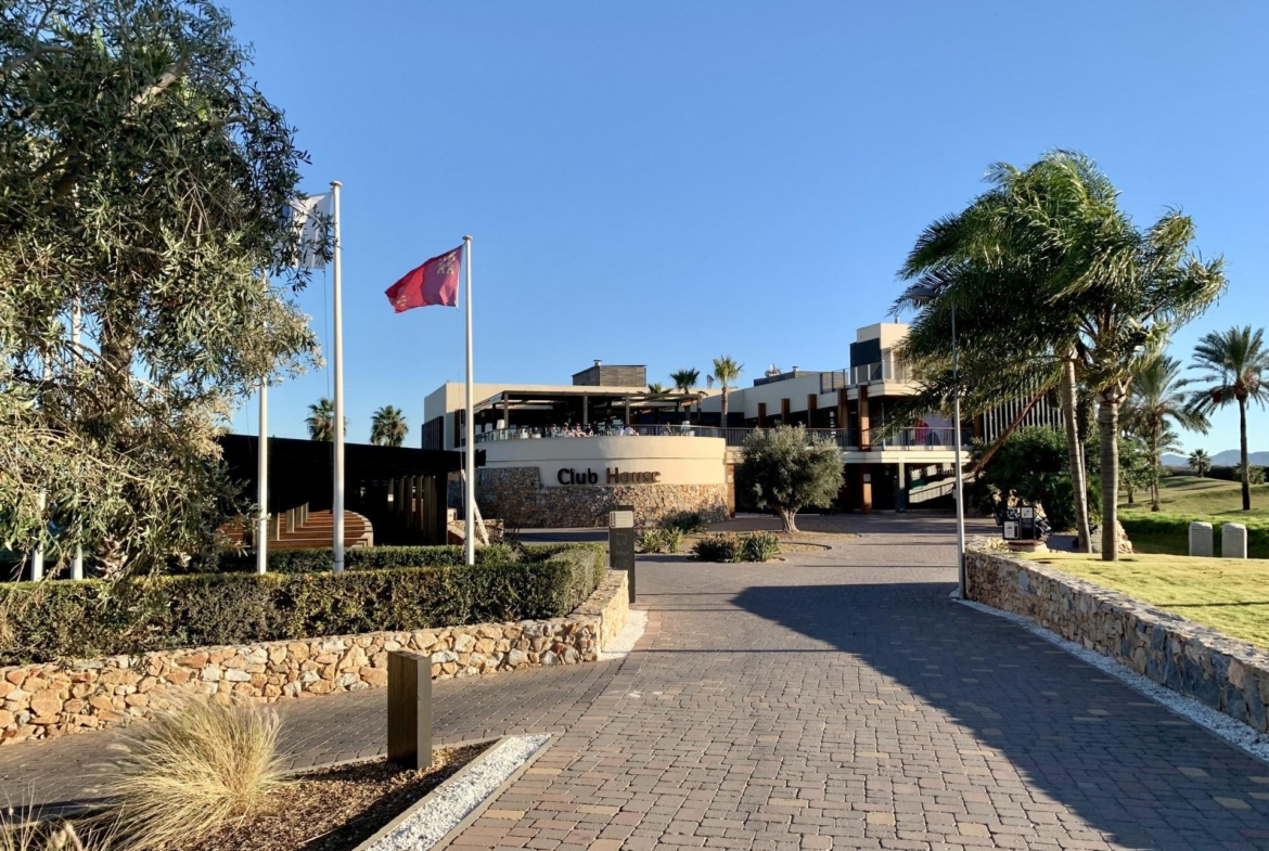 Elegant clubhouse entrance with landscaped gardens and palm trees at Roda Golf, perfect for modern 3-bedroom penthouse living in San Javier.