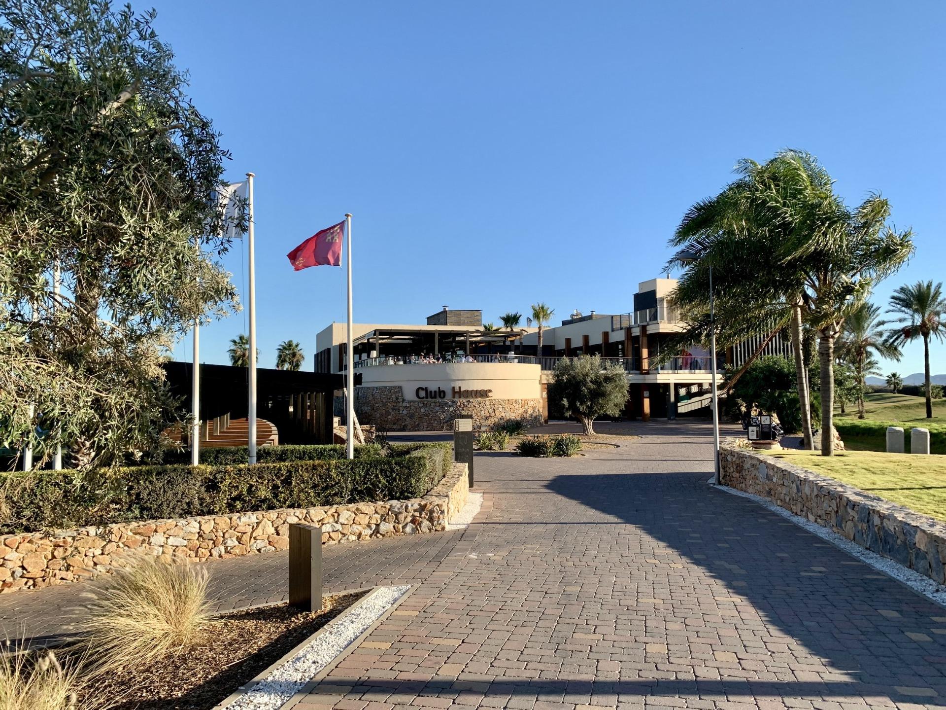 Elegant clubhouse entrance with landscaped gardens and palm trees at Roda Golf, perfect for modern 3-bedroom penthouse living in San Javier.