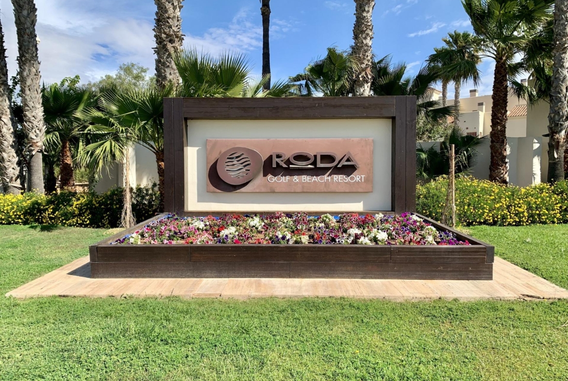 Lush landscaped entrance with tropical palms and vibrant flowers at Roda Golf & Beach Resort near San Javier, ideal for luxury living
