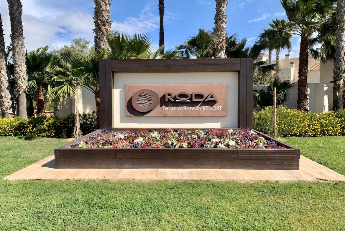 Lush landscaped entrance with tropical palms and vibrant flowers at Roda Golf & Beach Resort near San Javier, ideal for luxury living