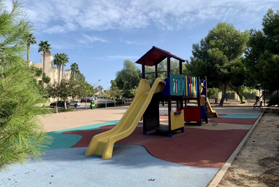 Bright, modern playground area surrounded by lush greenery near the luxury 3-bedroom penthouse in Roda Golf, San Javier.