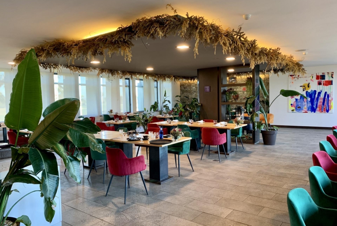 Bright, modern dining area with eclectic seating and lush plants, showcasing elegant living spaces in a luxury 3-bedroom bungalow in Roda Golf, San Javier.