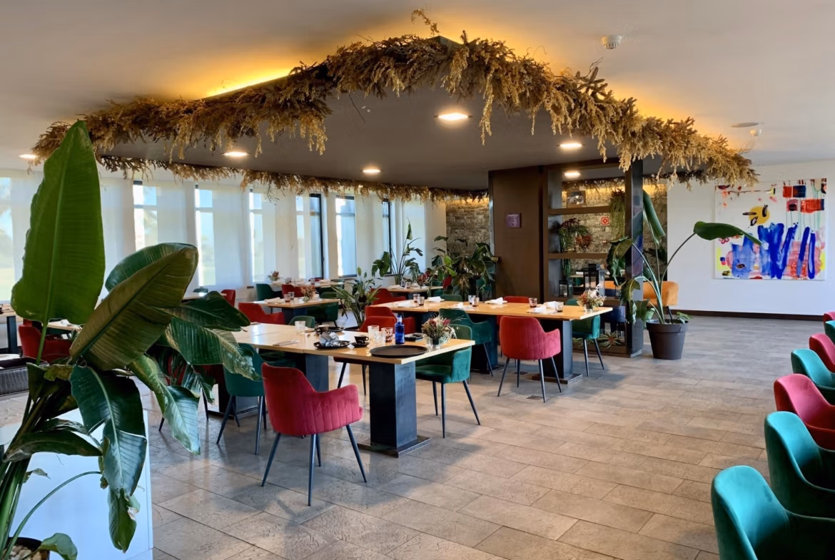 Bright, modern dining area with eclectic seating and lush plants, showcasing elegant living spaces in a luxury 3-bedroom bungalow in Roda Golf, San Javier.
