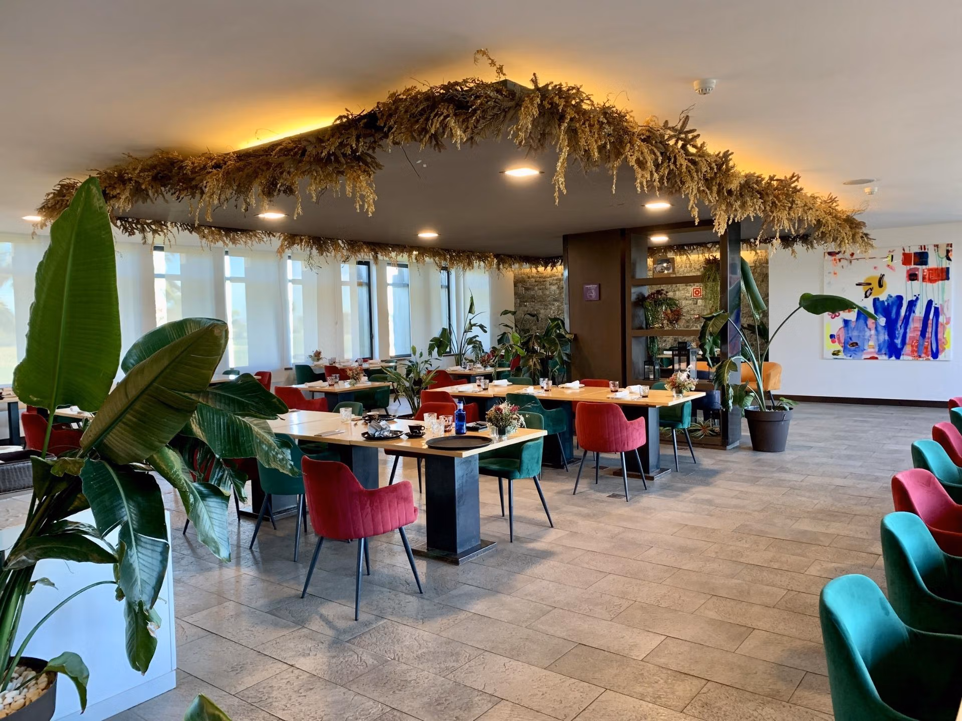 Bright, modern dining area with eclectic seating and lush plants, showcasing elegant living spaces in a luxury 3-bedroom bungalow in Roda Golf, San Javier.